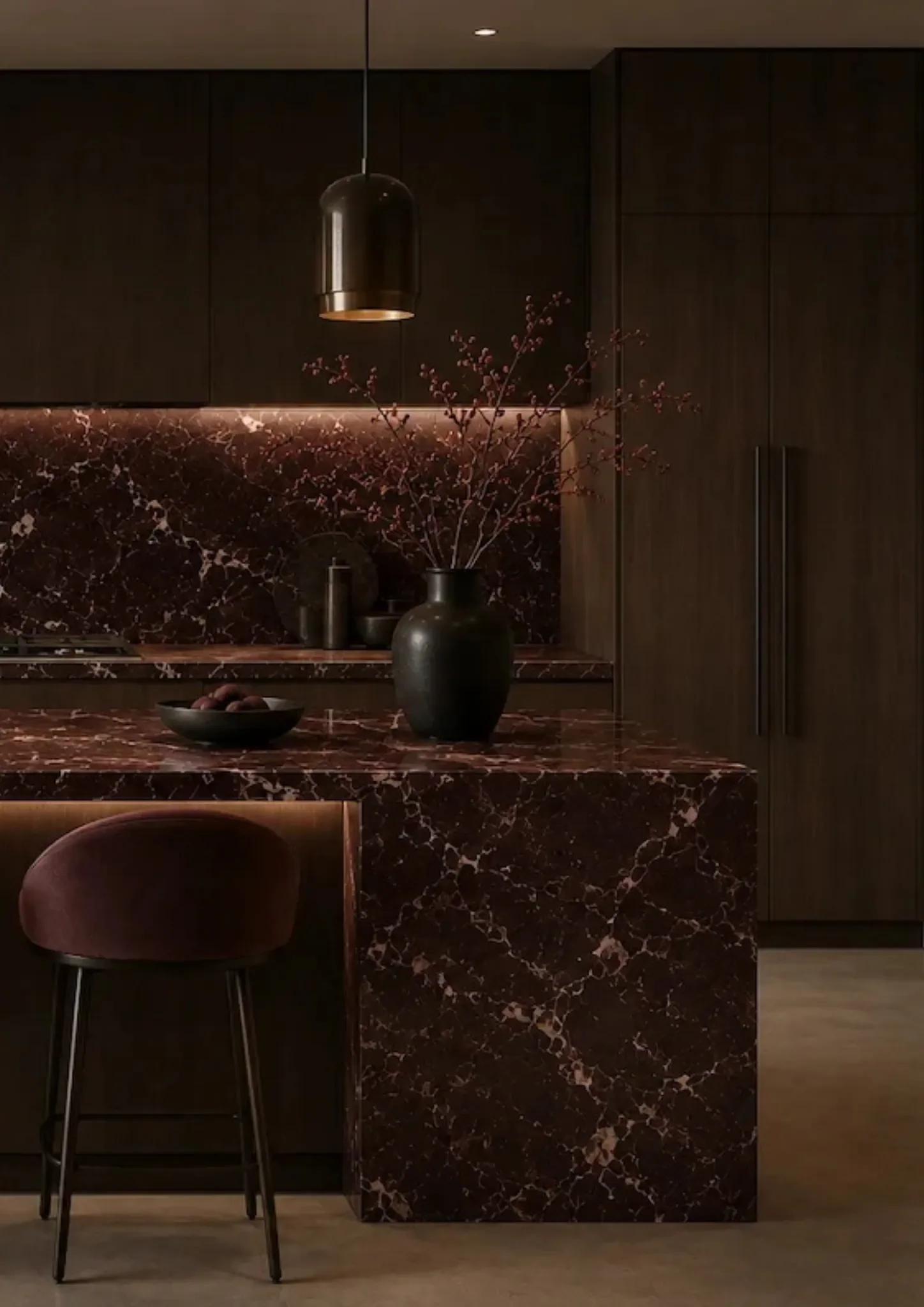 Close-up of a dark red veined natural stone waterfall kitchen island in a contemporary interior.