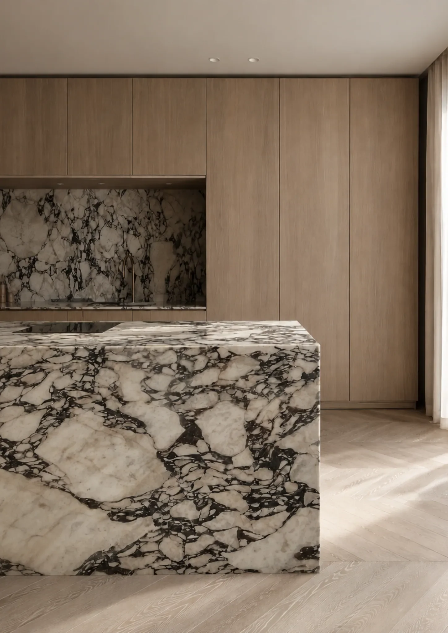 Natural stone kitchen island with dramatic veining and a substantial waterfall edge.