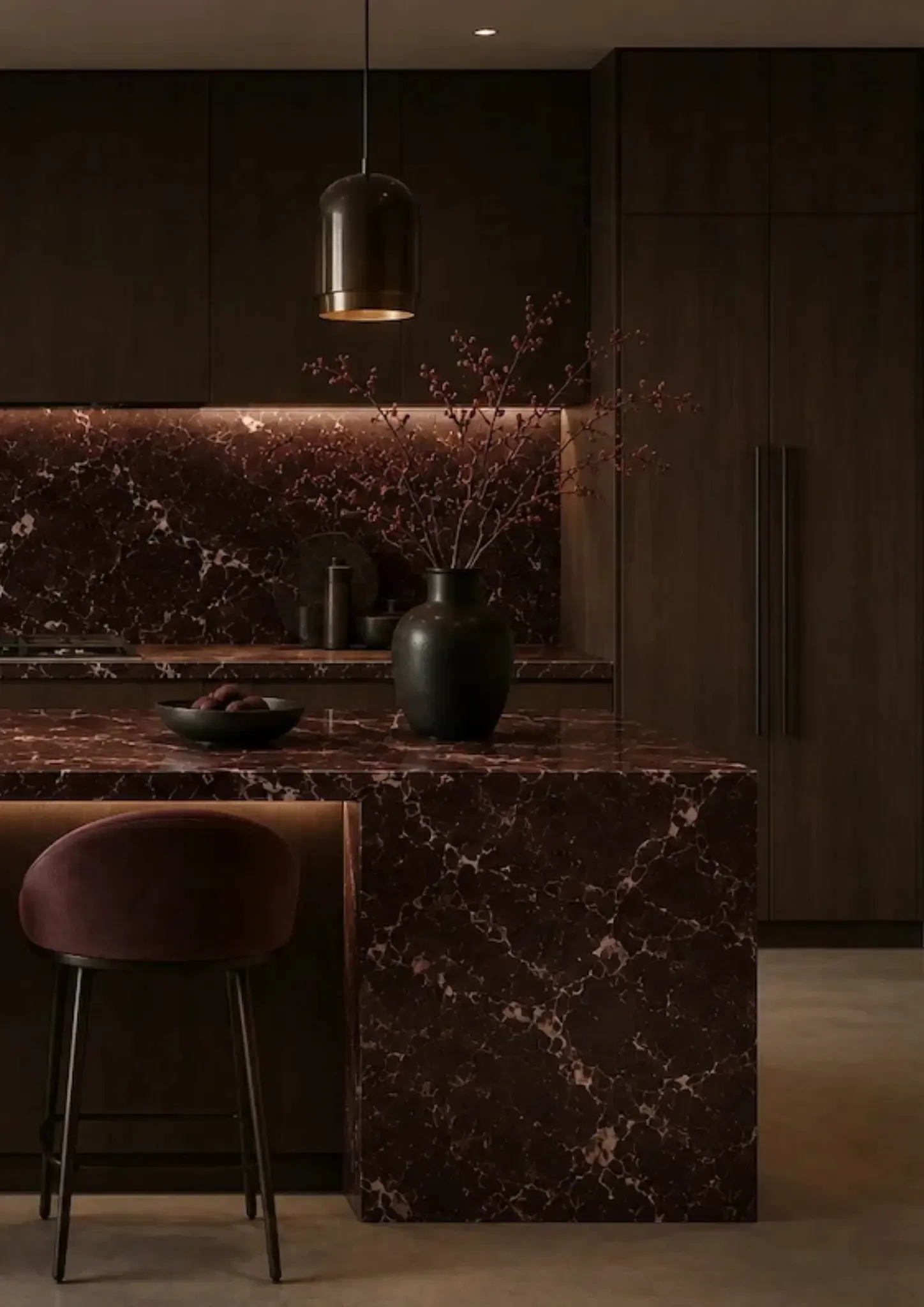 Modern kitchen with dark wood cabinets, red and black marble countertop, a vase with bare branches, black bowls, and a black pendant light hanging from the ceiling.