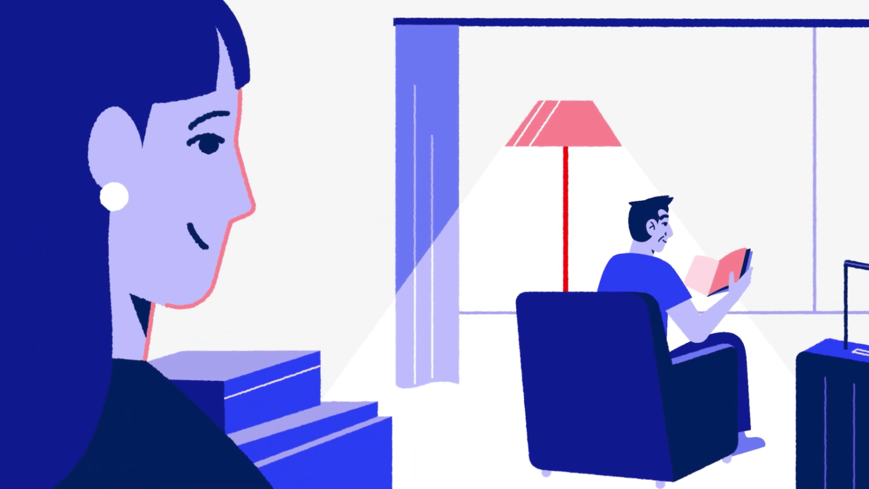 Woman watching a man sitting in an armchair reading a book in a softly lit living room