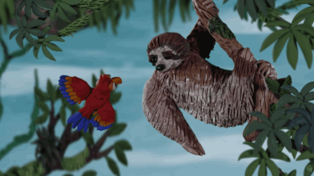Sloth hangs from a tree branch while a colorful bird flies nearby.