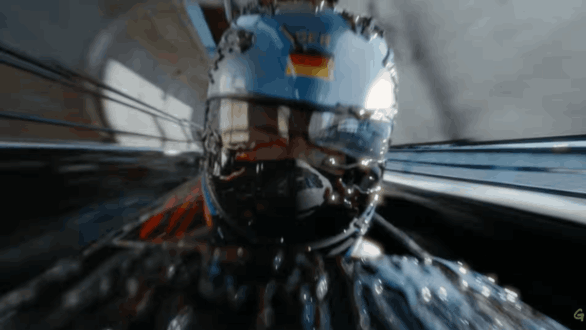 Skeleton athlete racing headfirst down icy track wearing helmet