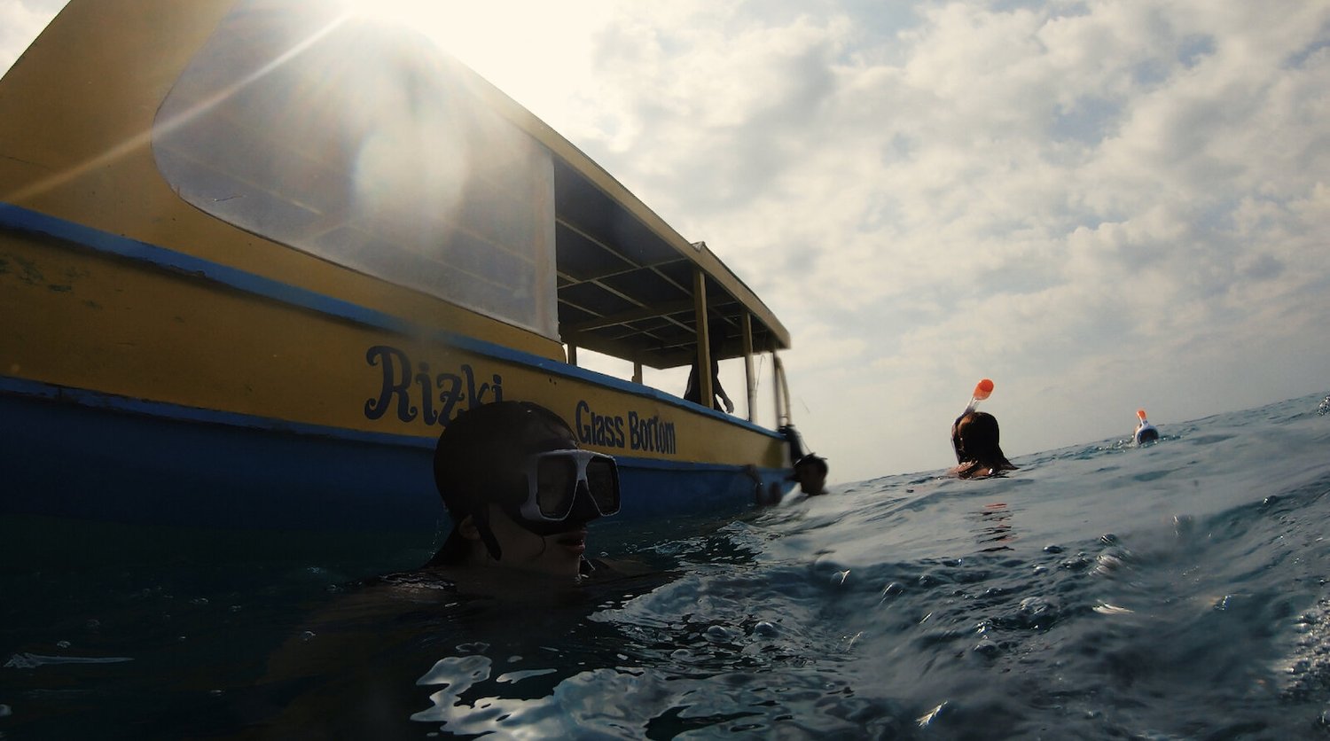 Blogger Katie Caf getting hit in the head by a glass-bottom boat on a Gili Trawangan Snorkel tour. 