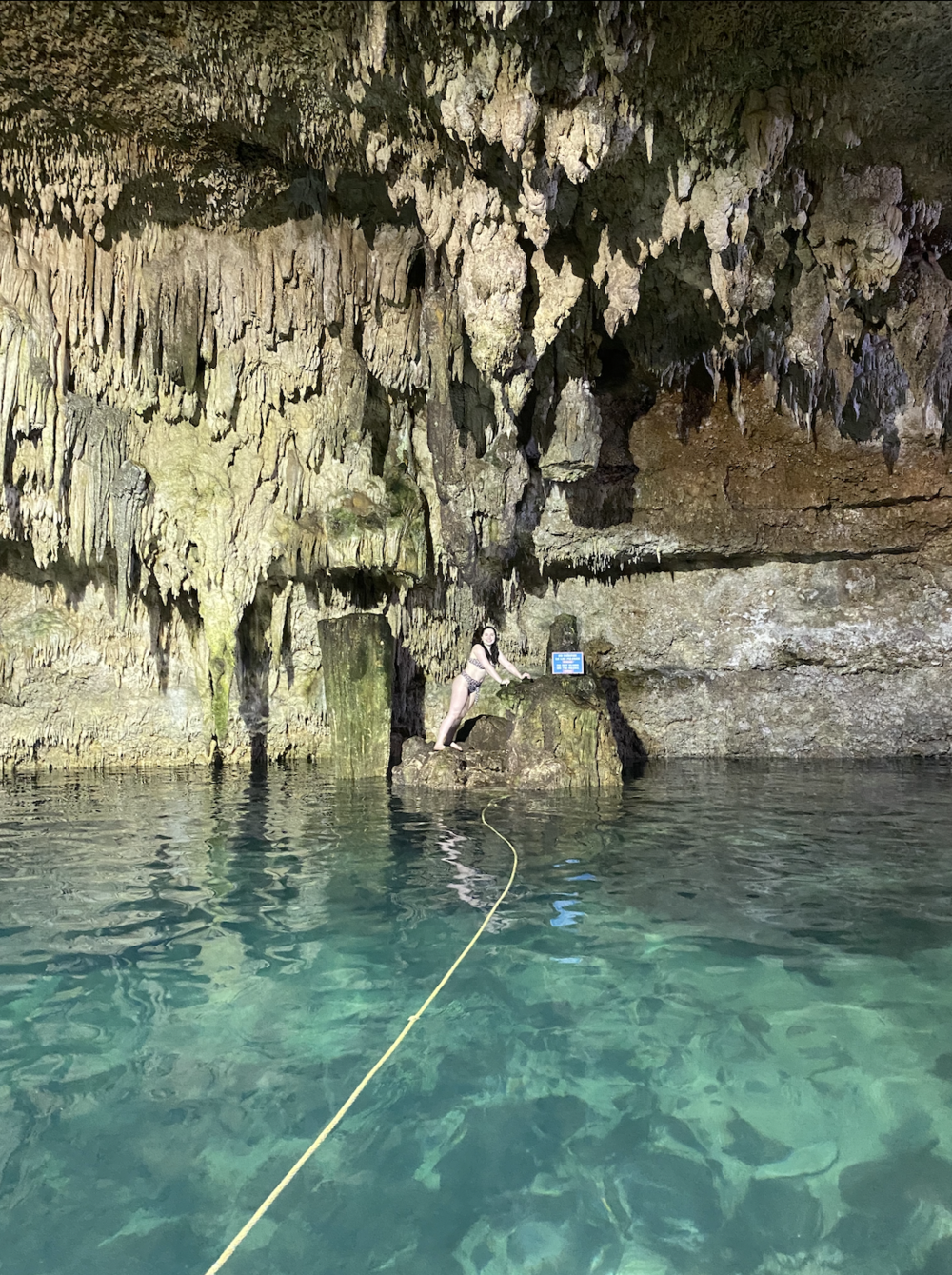 a girl standing on a rock in cenote choo ha in coba, mexico.