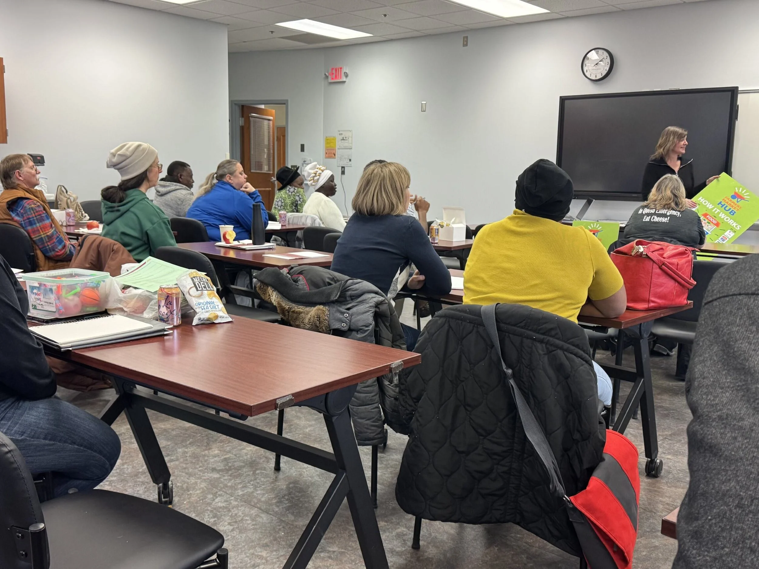Attendees sitting at desks during an indoor presentation session.