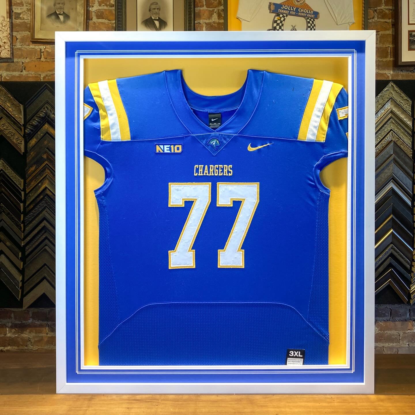 One of the many jerseys we finished in time for Christmas. We specialize in jersey framing. All jerseys are formed, shaped and sewn. In this case we used our raised mat approach rather than our traditional shadowbox approach. The colors on this desig