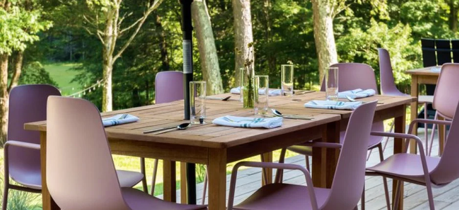 Outdoor dining deck with modern seating overlooking wooded scenery at a Catskills boutique hotel.
