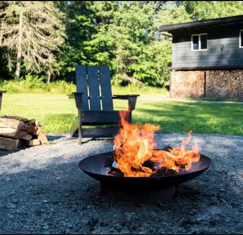 Outdoor fire pit area with Adirondack chairs at a peaceful Catskills mountain retreat surrounded by nature.