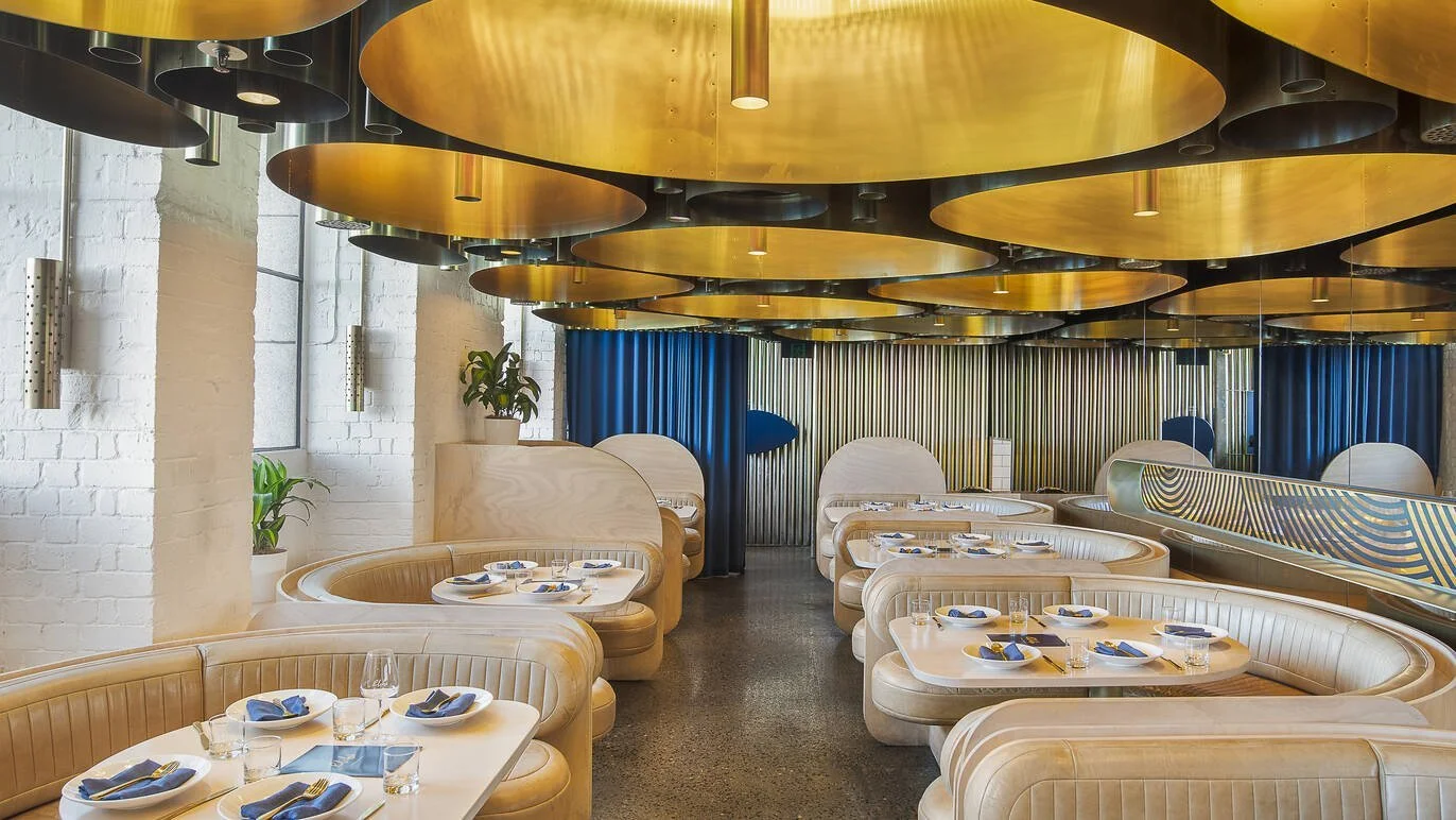 Curved white booths beneath the gold ceiling at Elchi