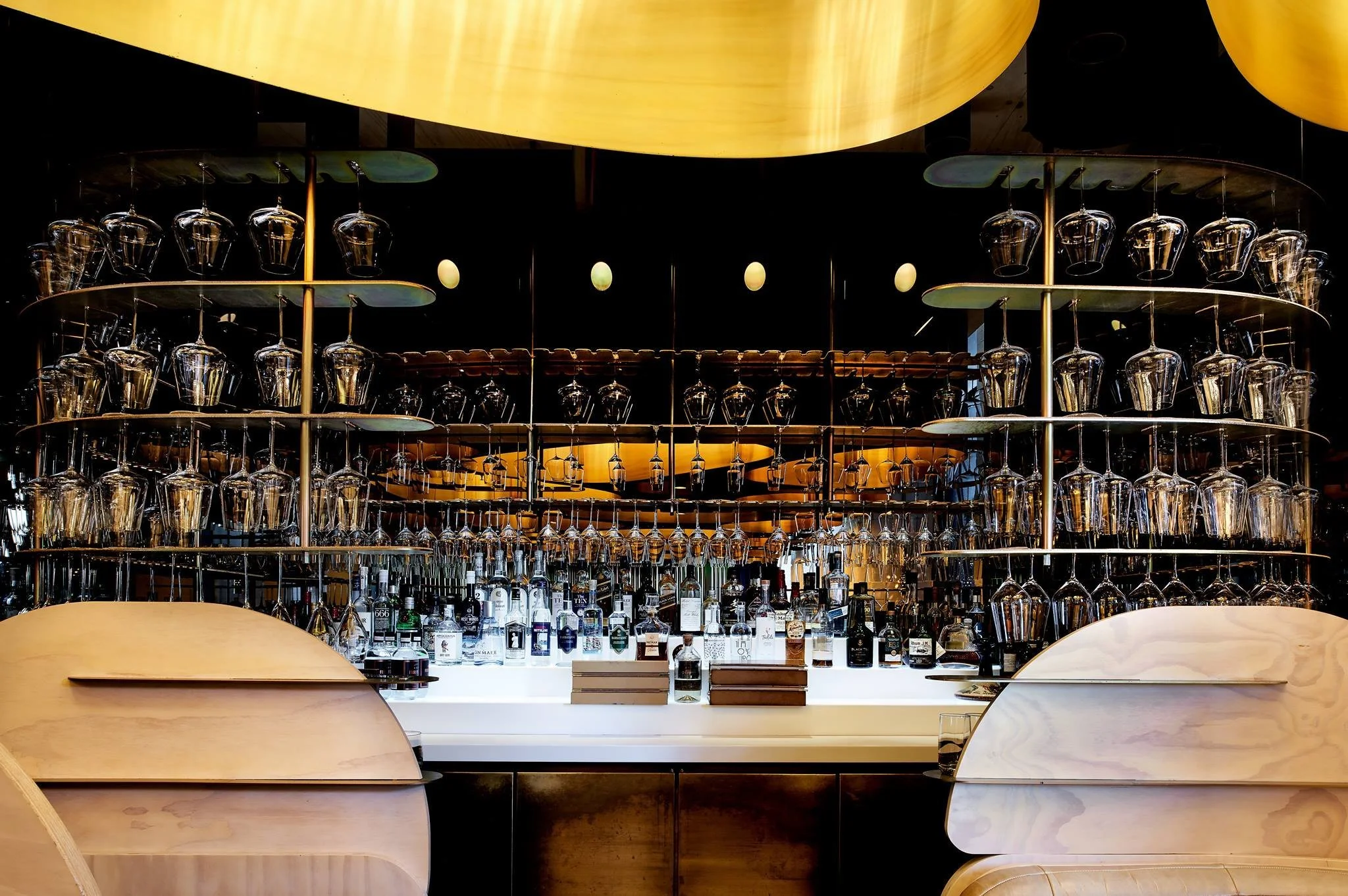 Elchi bar with backlit bottle shelves under the gold ceiling