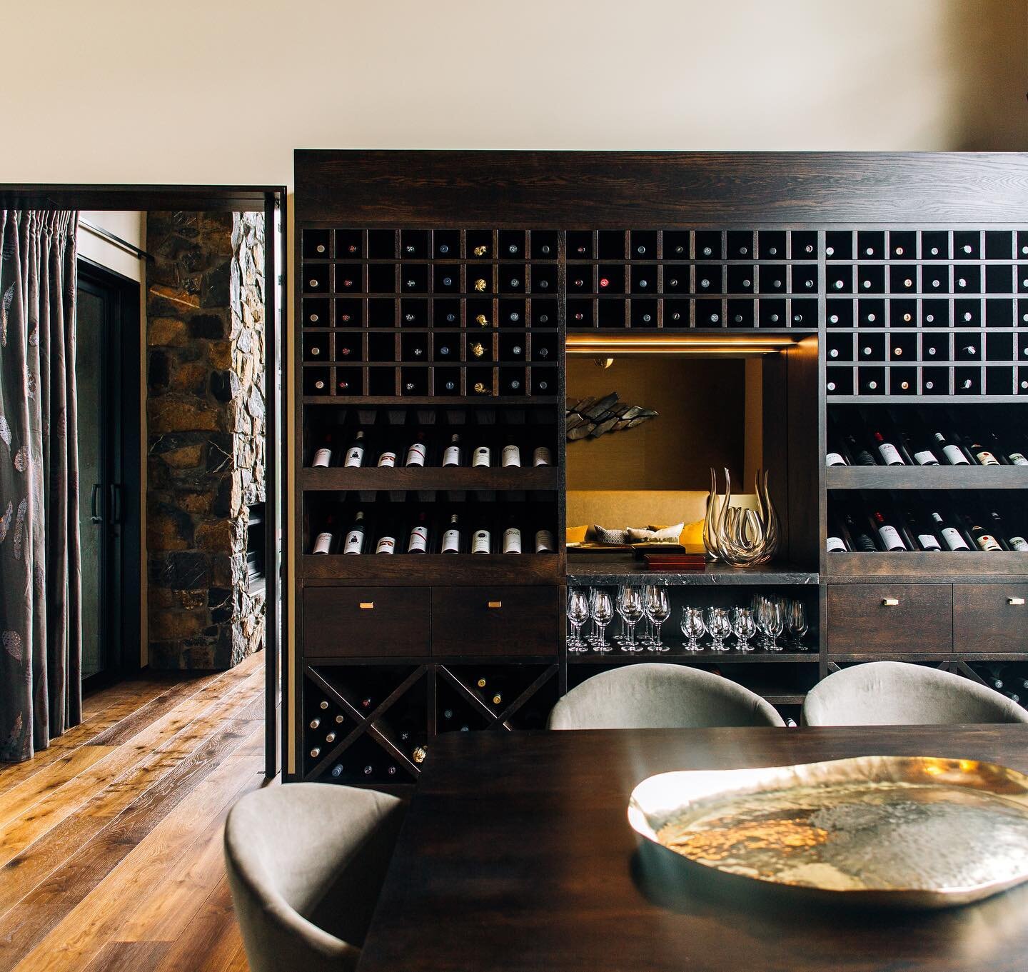 We custom designed this impressive oak, granite and bronze glass wine storage and display cabinet to breach the divide between a casual banquette diner space and formal seated dining room. Functional, and also a beautiful fixed furniture piece in it&