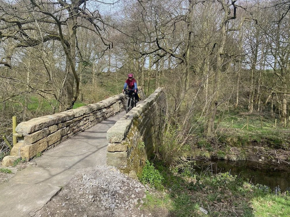 Cycling over a packhorse bridge near Penistone, South Yorkshire