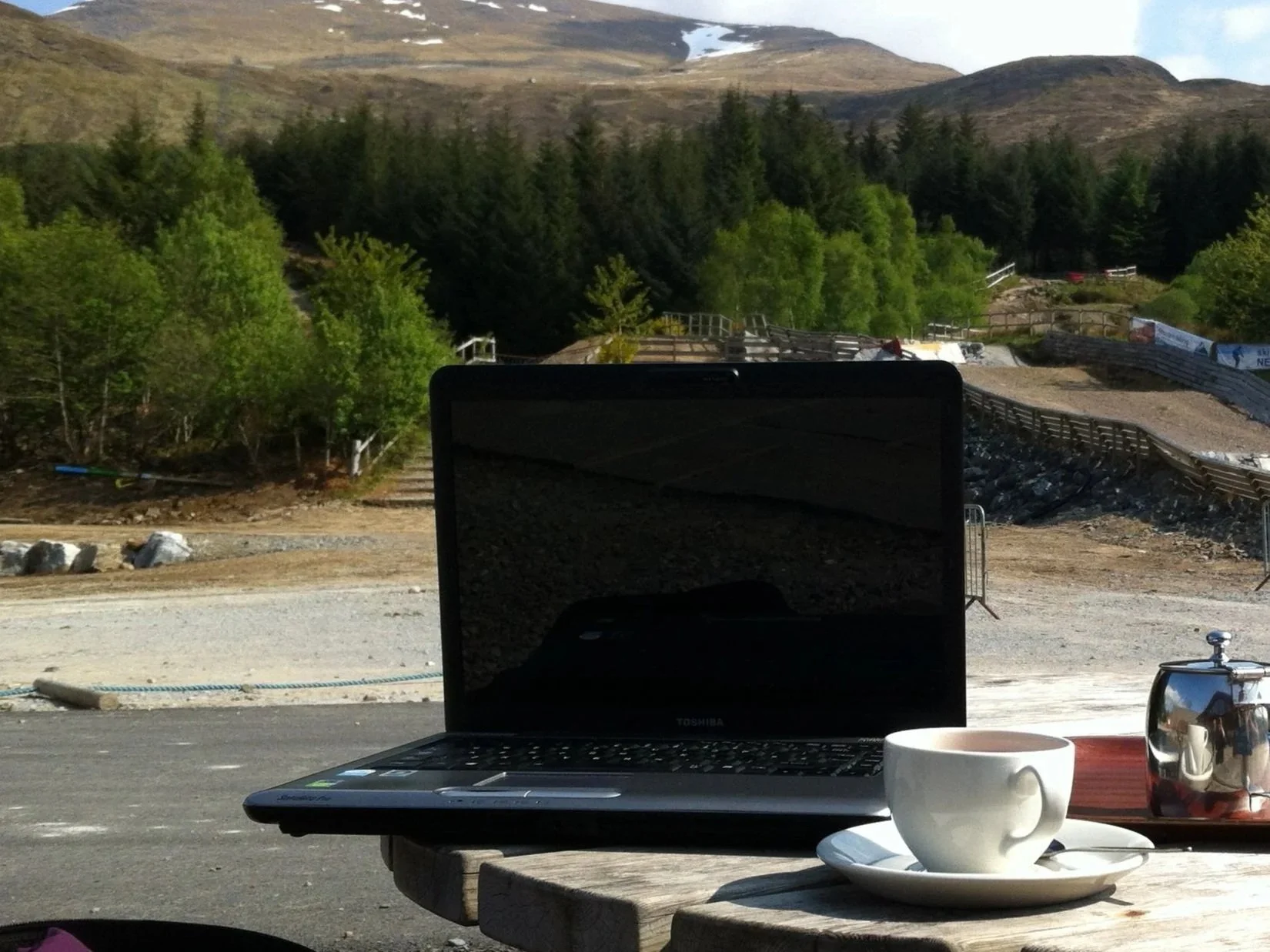Laptop with a view of Aonach Mòr, Scotland, with a cup of tea