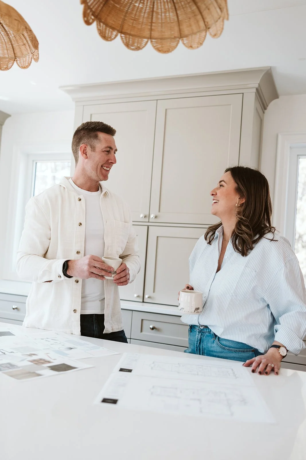 Lead construction manager and lead interior designer at Park Road Deisgn & Build smiling while looking over floor plans for a farmhouse renovation and addition project in Norththuberland County..