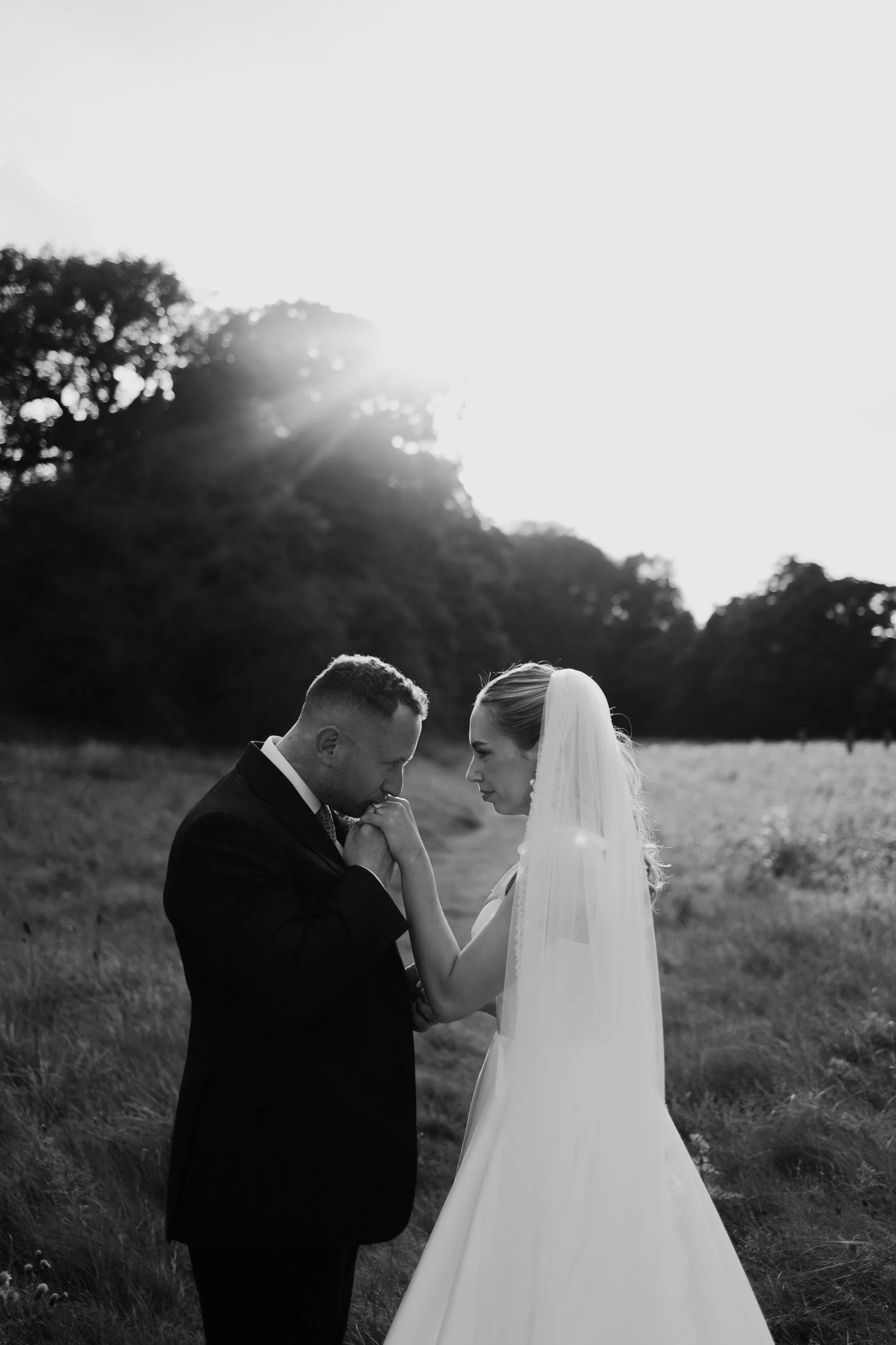 Groom kisses brides hand during wedding photos in Derbyshire