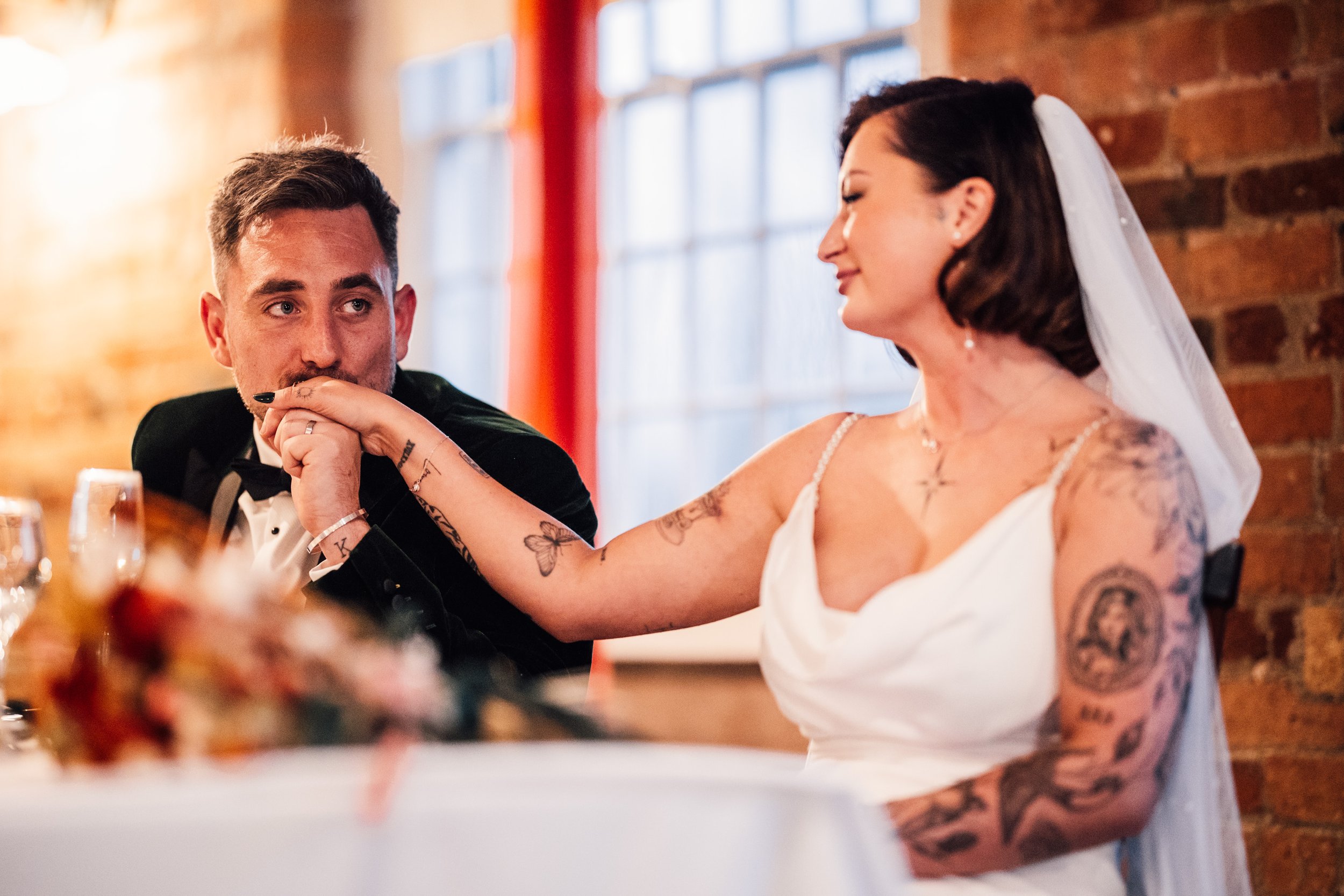 Groom kisses brides hand during speeches at The West Mill Wedding
