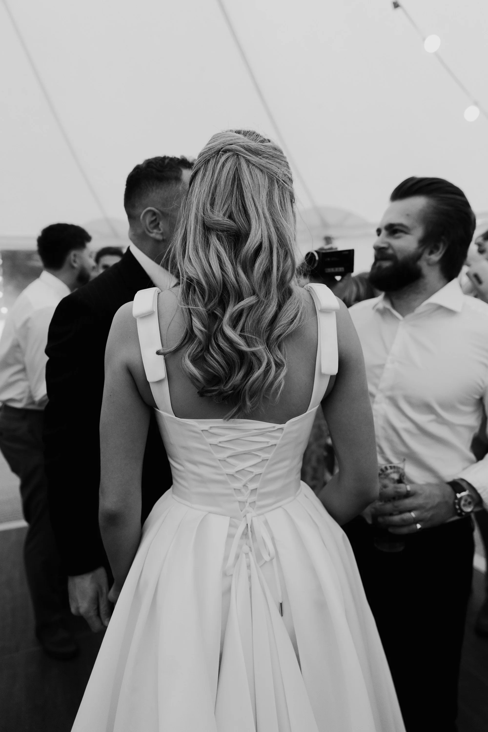 Lace corset style wedding dress and half up bridal hairstyle photographed during candid moment at peak district wedding