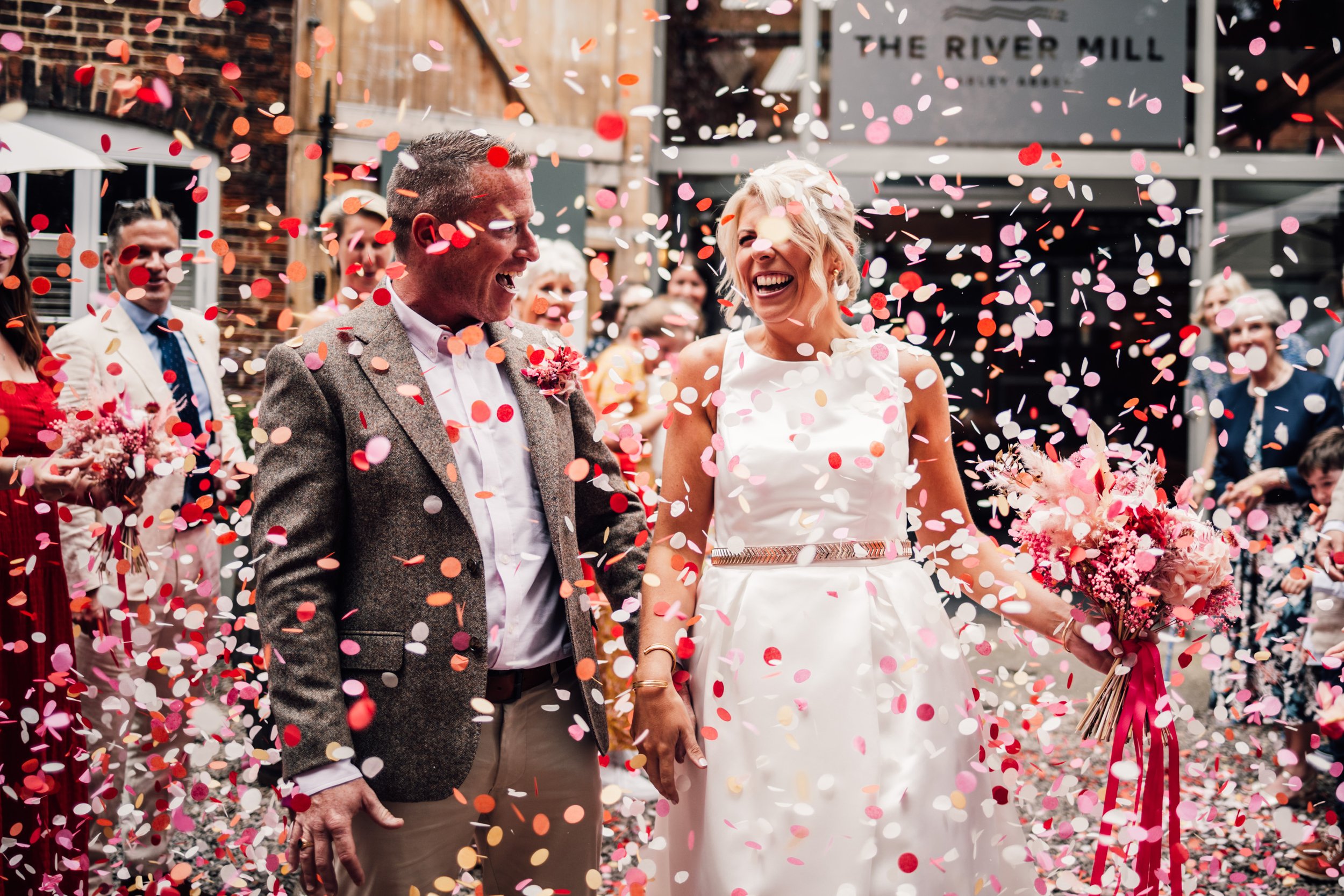 Bride and groom walking through confetti at The River Mill Derby wedding
