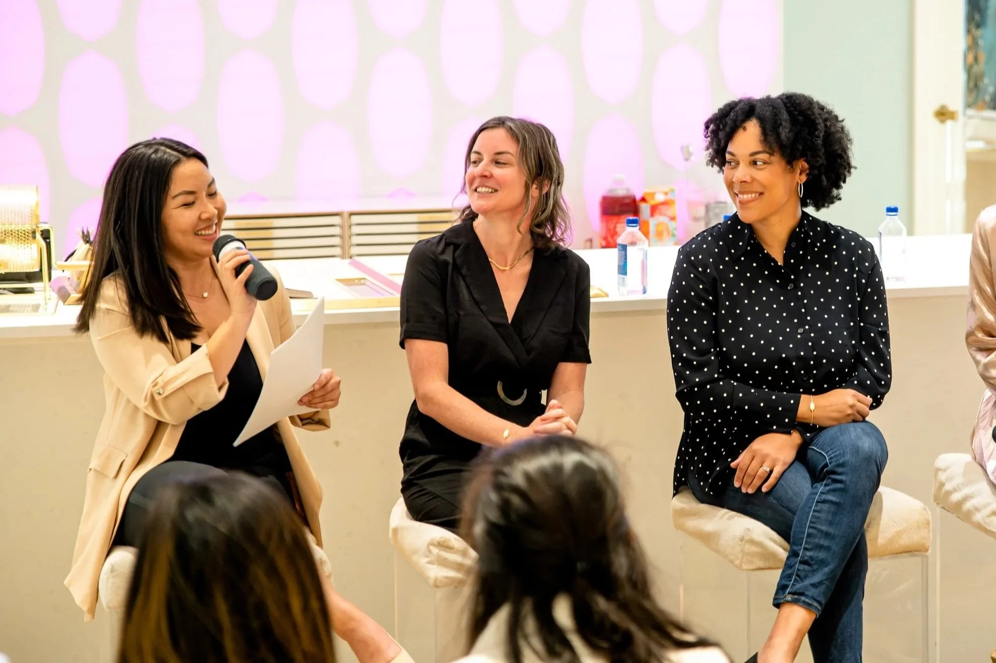 Women panelists conversing in front of an audience
