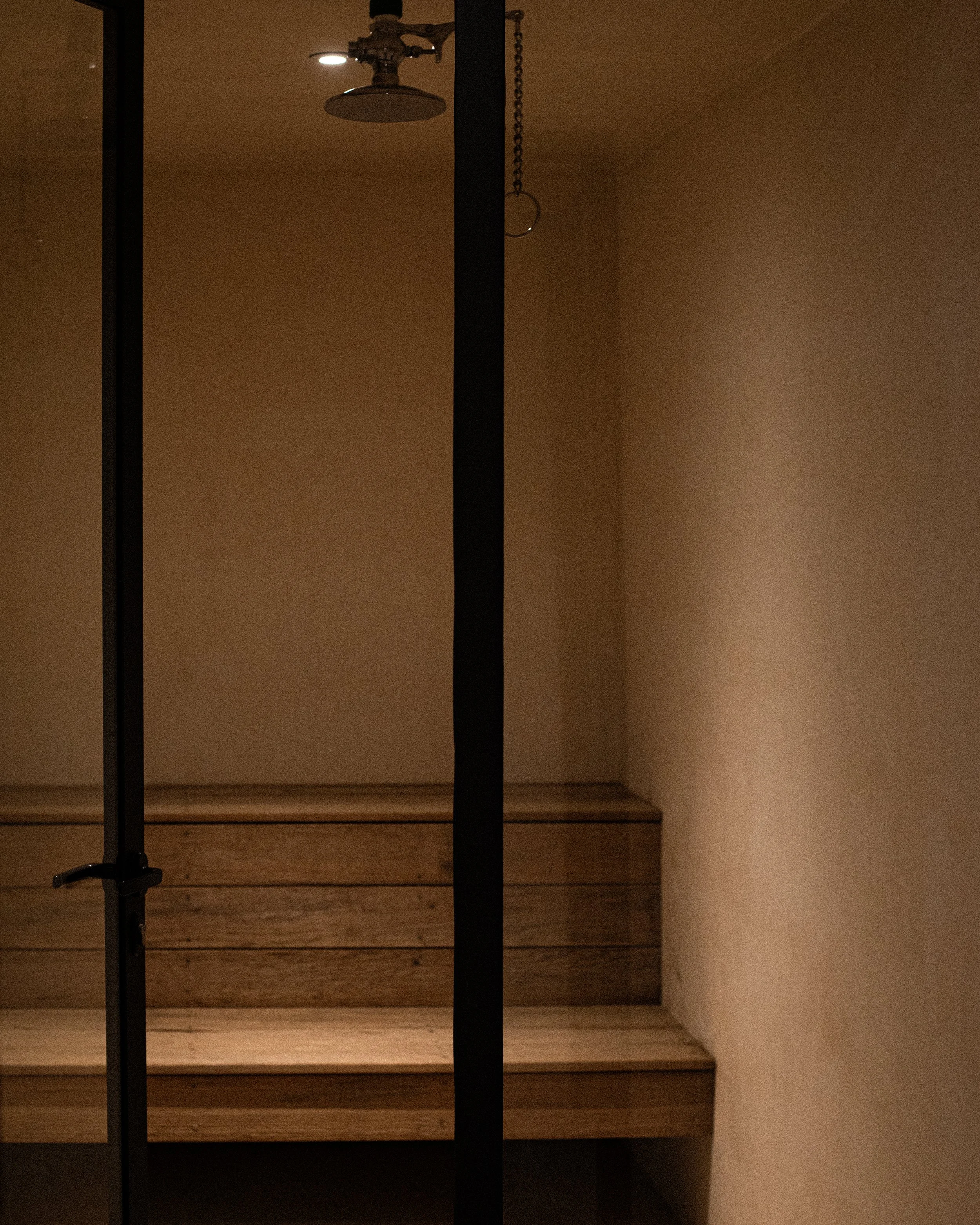Interior de una sauna, con vaporera y bancos de madera.