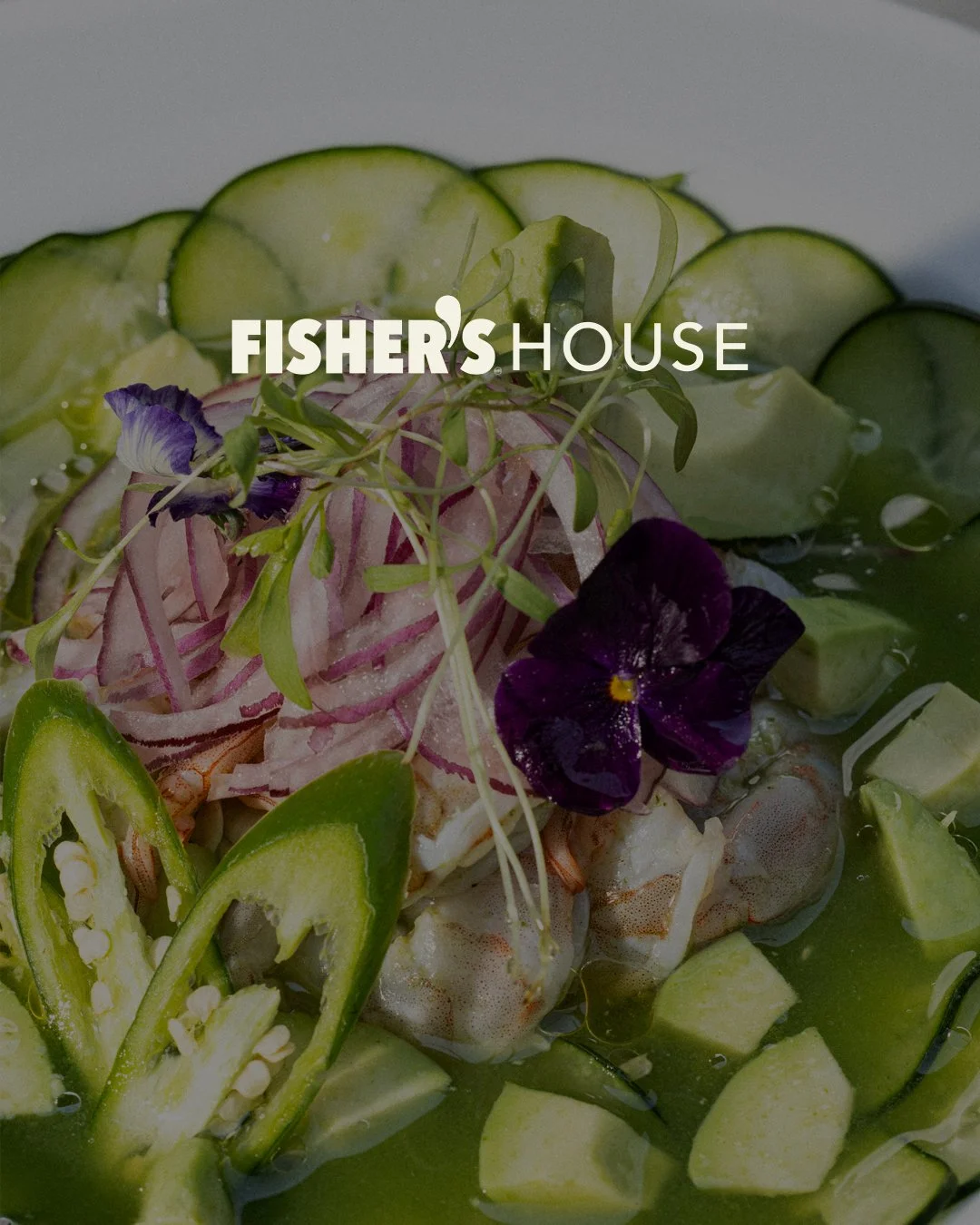 Ensalada con camote, calabacín, aceitunas, cebolla, brotes y flores comestibles, en un plato con salsa verde