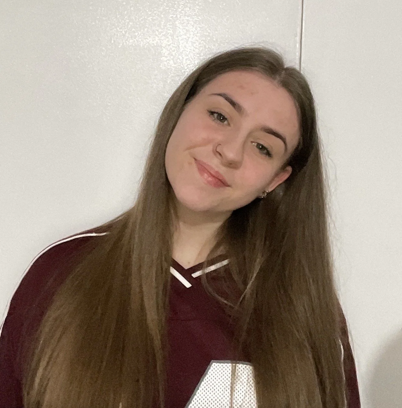 A young women in long hair, with a red teeshirt.