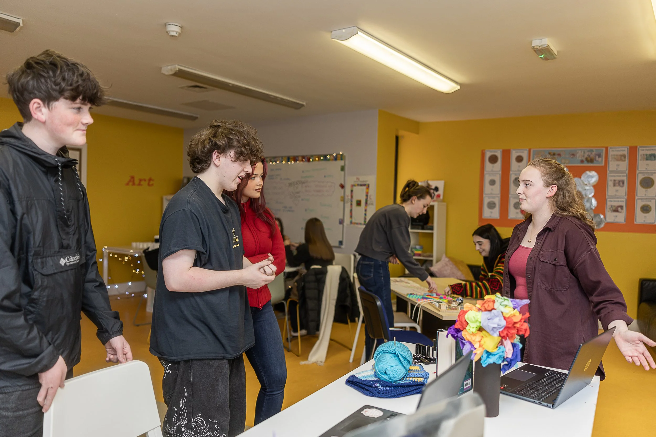 Young people sharing their project ideas at a community centre, with a group of young people listening.