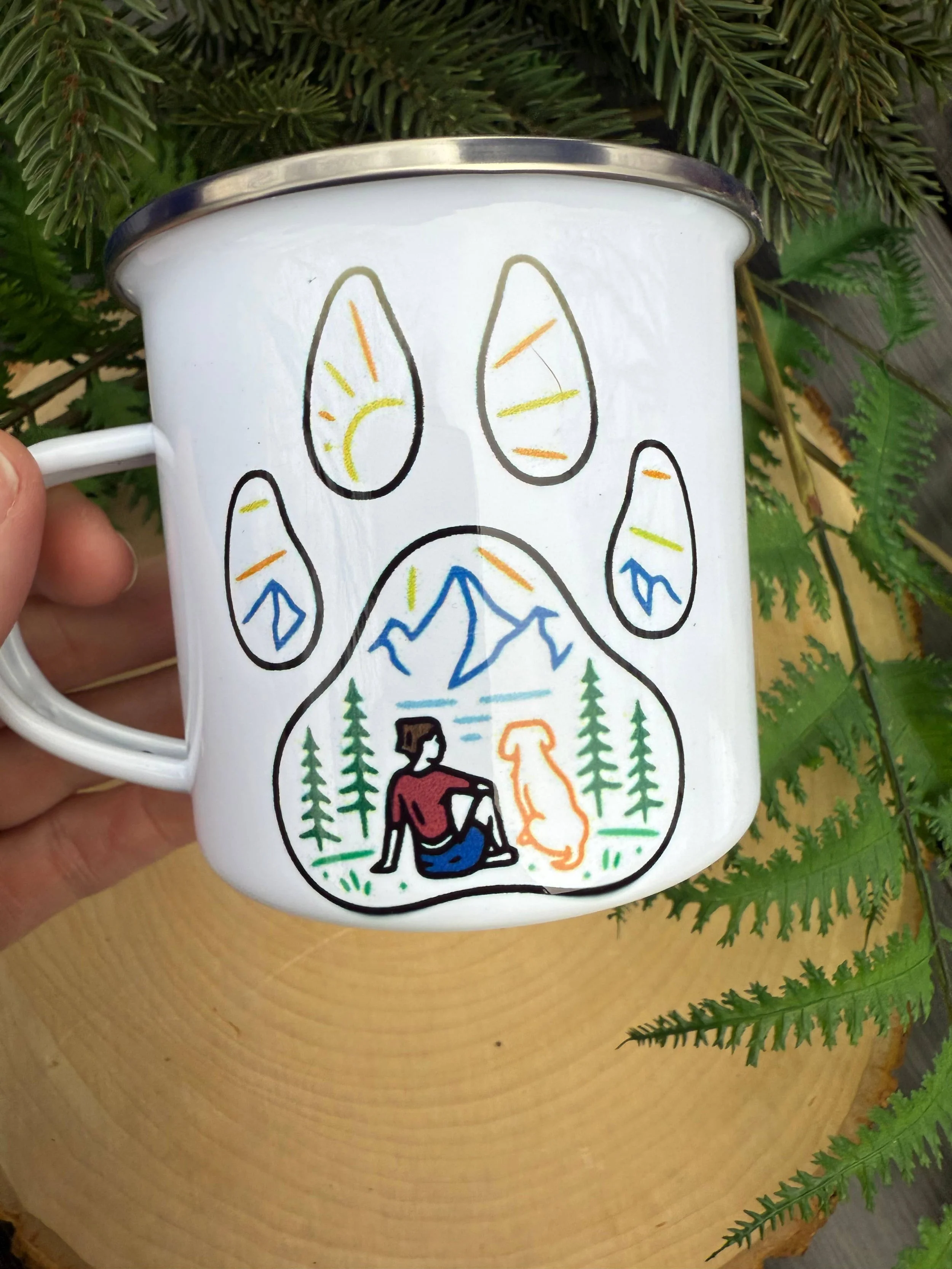 paw print enclosing a serene scene of a girl and her dog soaking in a breathtaking mountain range