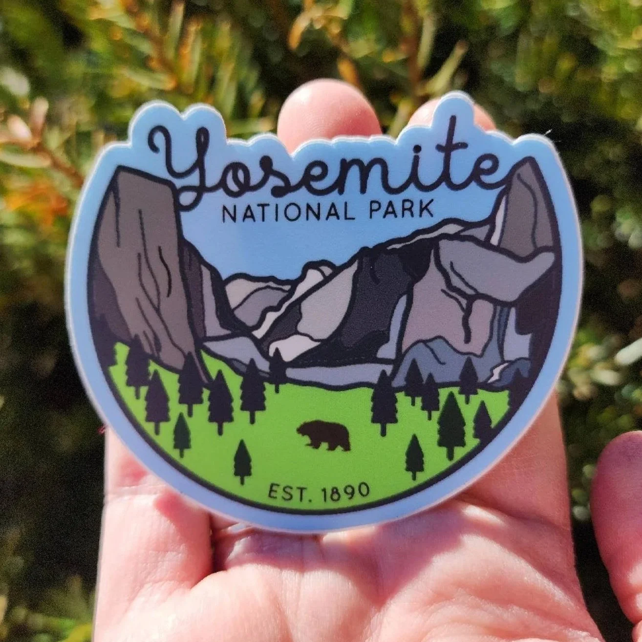 Yosemite Blue Half Circle Sticker in the palm of a women's hand