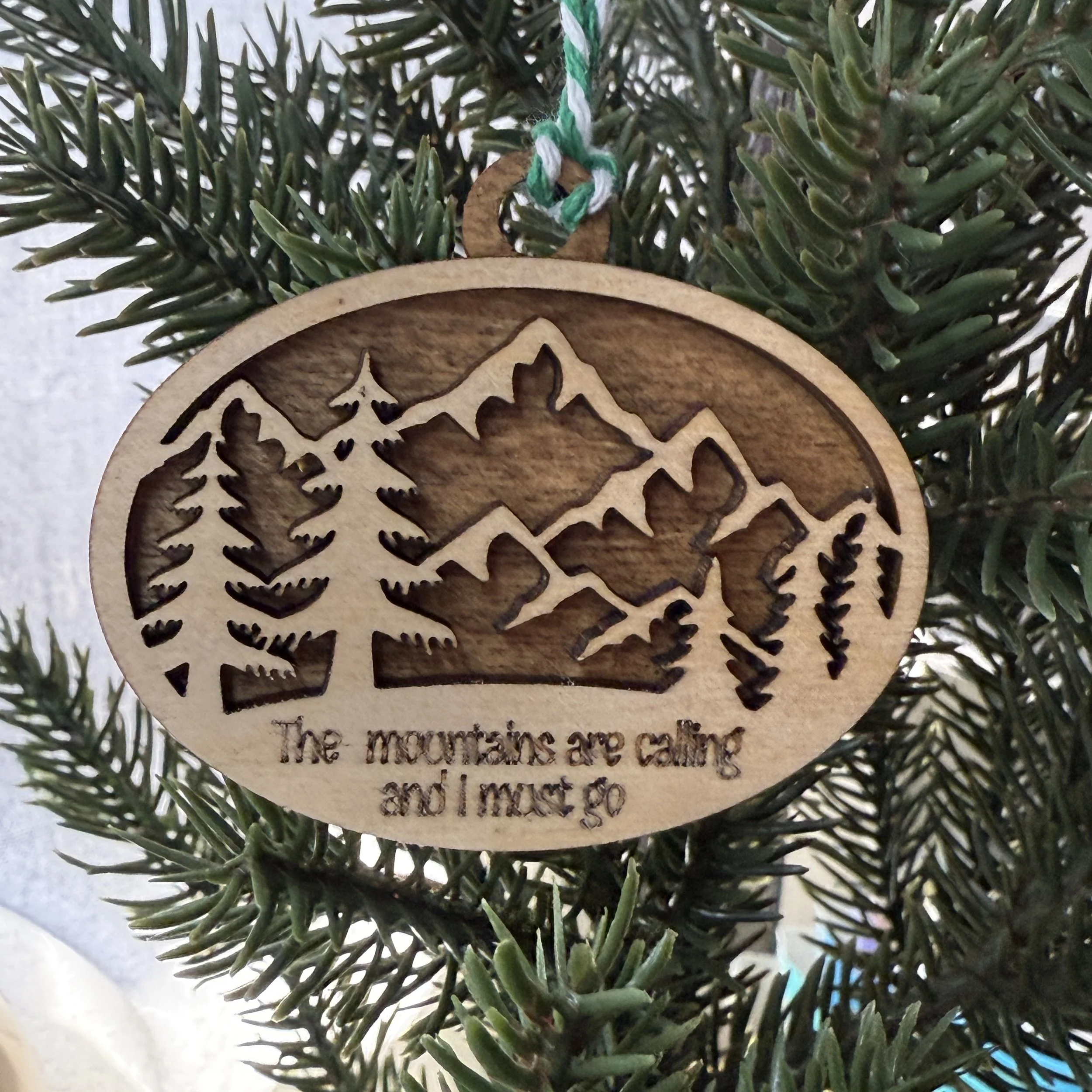 The mountains are calling and I must go text engraved on the wooden mountain ornament
