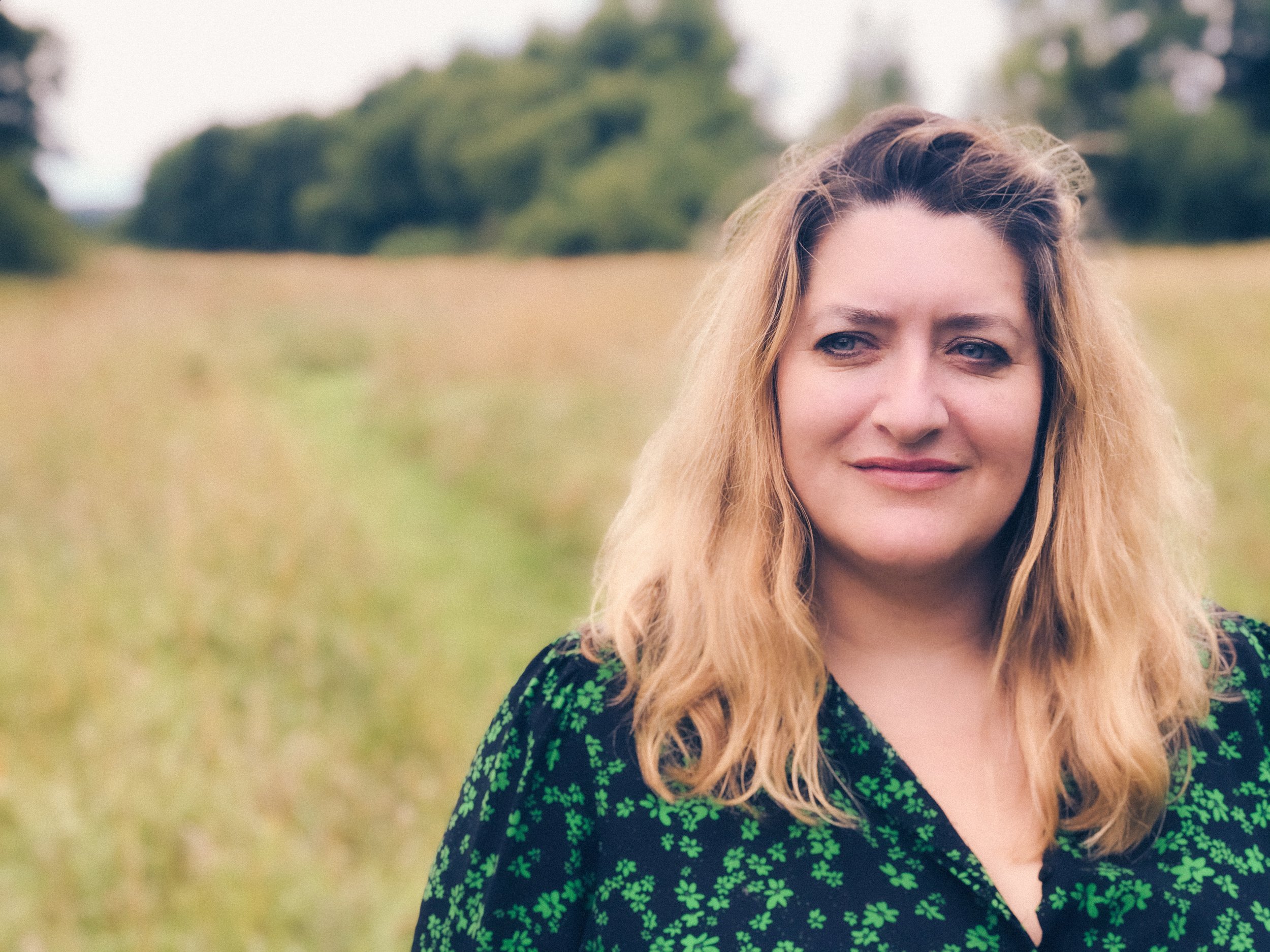 Tash Willmore standing in a black and green floral dress