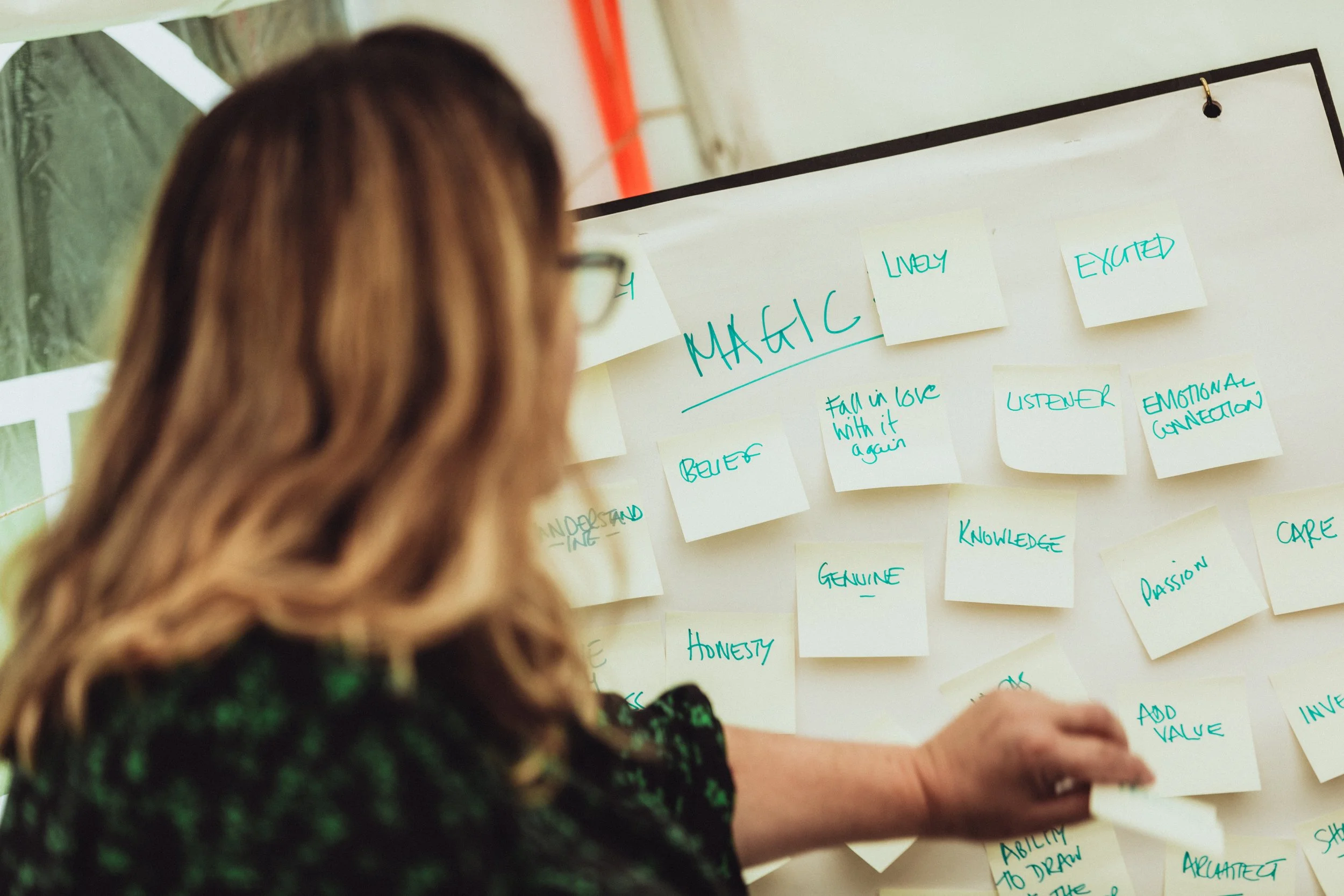 Tash Willmore standing a whiteboard with various post-it notes on