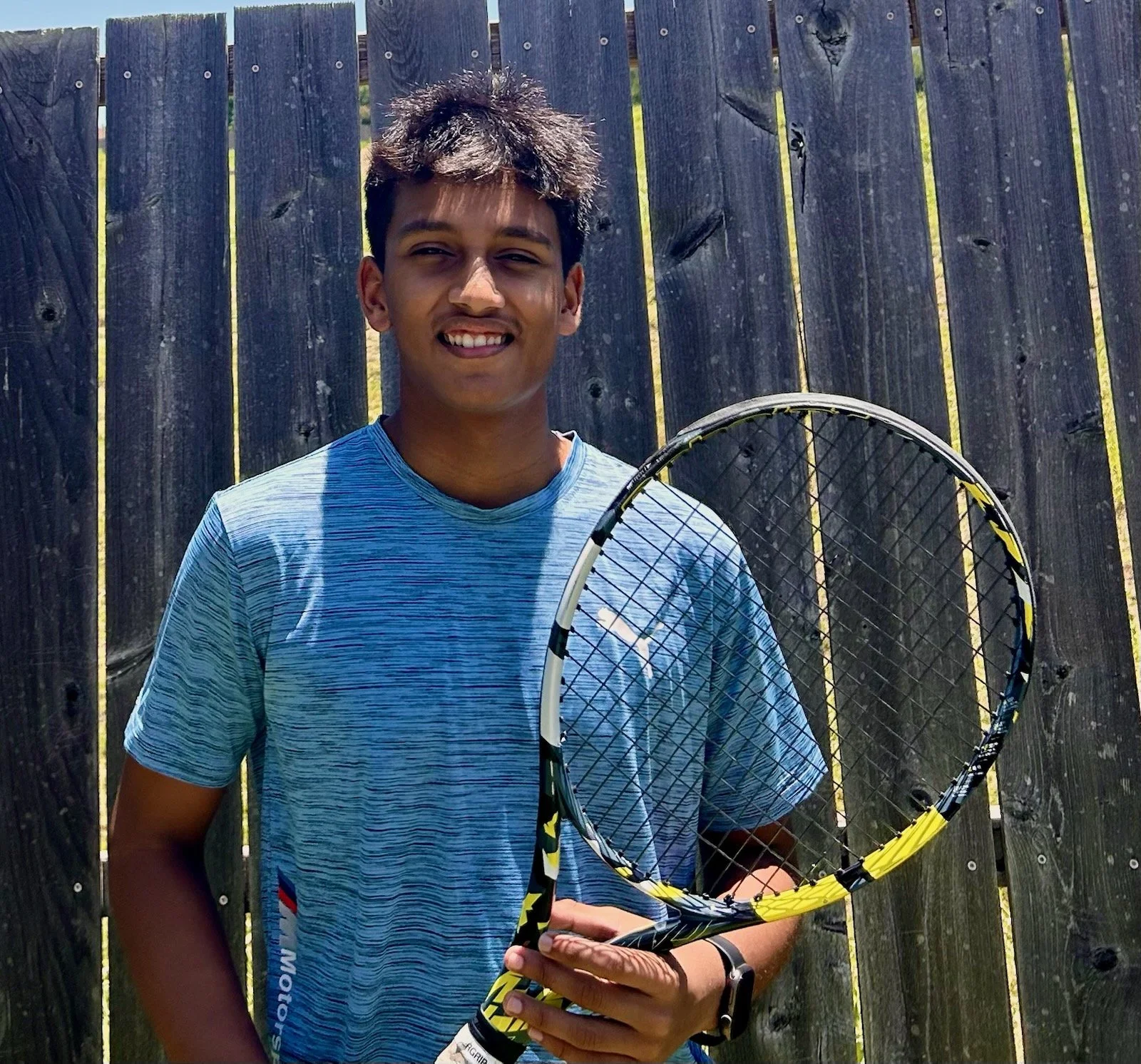 Assistant tennis coach Akarsh smiling on the court at Franco Racquet Sports in Dallas, TX