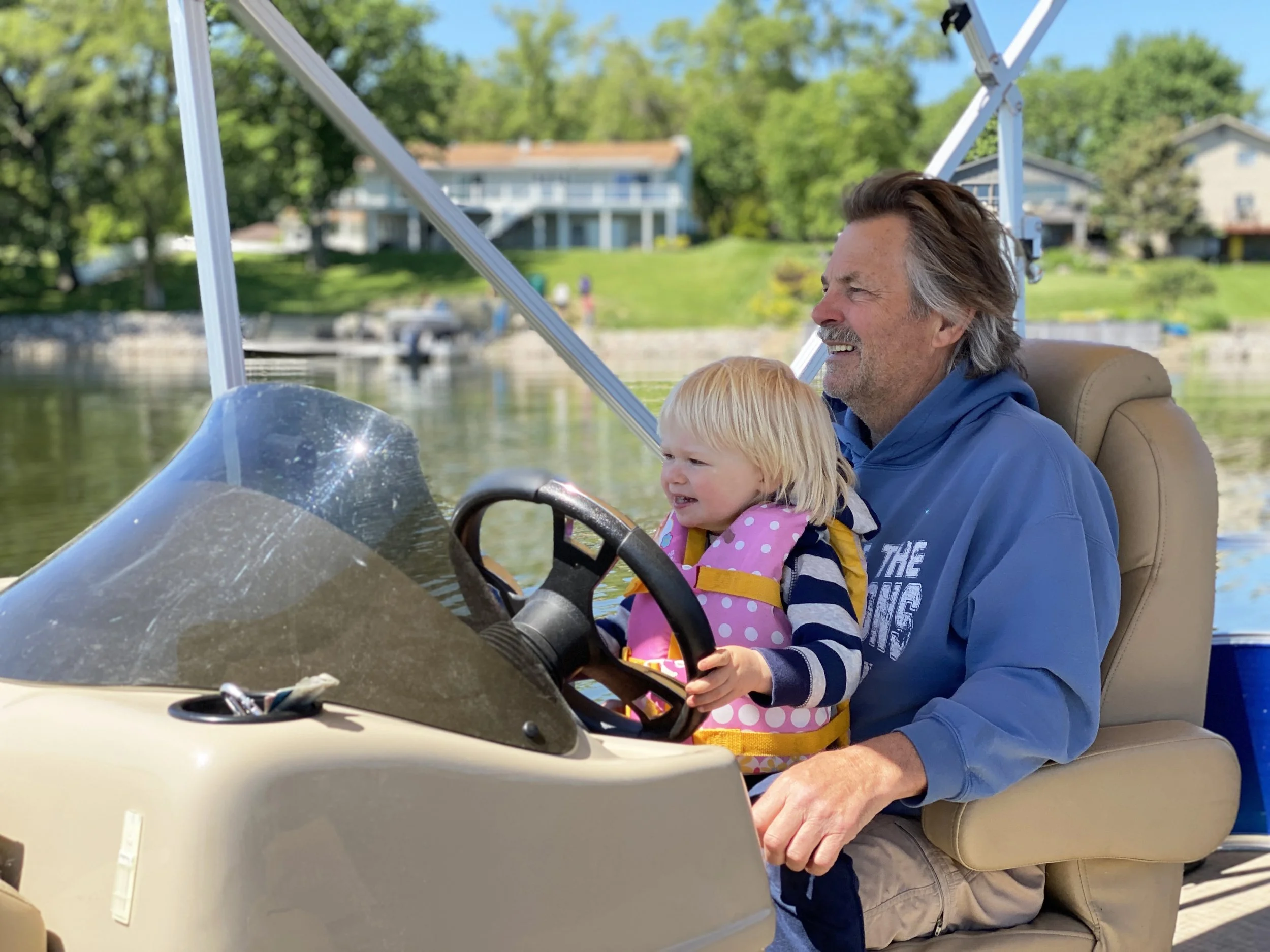 Hal driving Papa's boat. The lakehouse is a gathering place for the whole family. .jpg