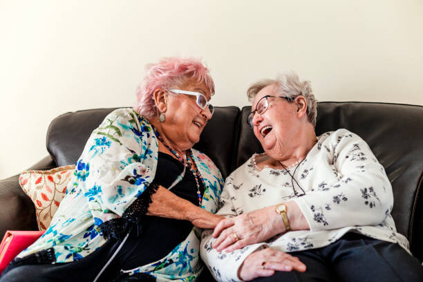 two older ladies smiling at one another with joy and friendship symbolizing the importance of secure attachment in the therapeutic relationship.