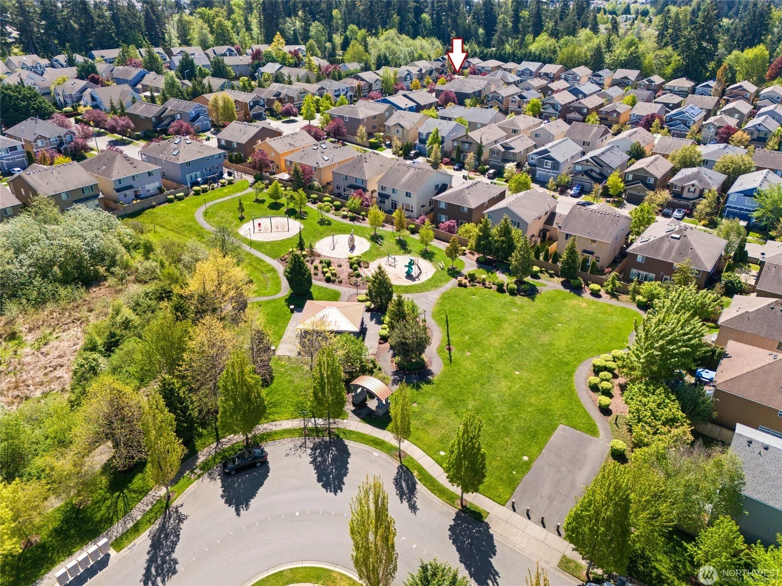 Aerial view of Mill Creek Meadows homes surrounding a community park with playground in Bothell, WA 98012