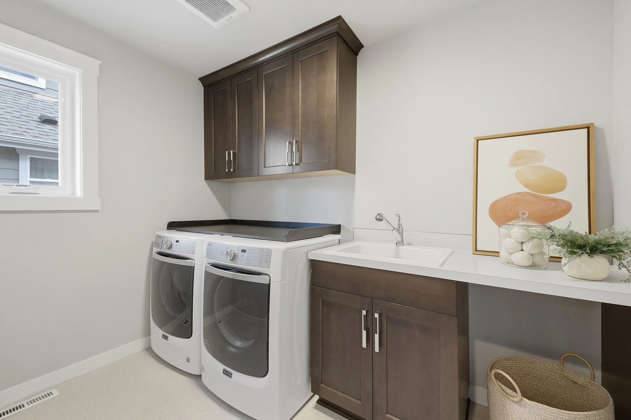 Laundry room with washer, dryer, and dark wood cabinetry, Redmond WA Burnstead home