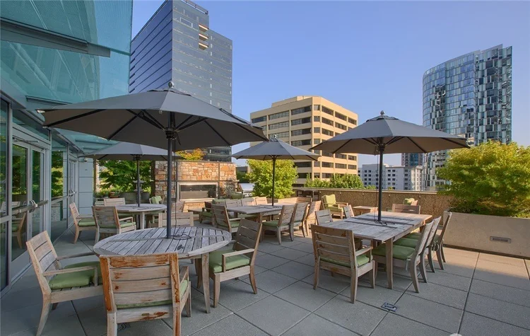 Rooftop terrace with outdoor dining and fireplace overlooking Downtown Bellevue