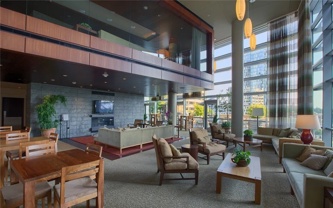 Two-story resident lounge with fireplace and floor-to-ceiling windows at Bellevue Towers