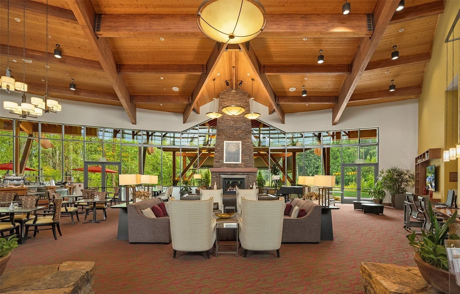 Cascade Club great room with stone fireplace and             vaulted timber ceiling at Trilogy Redmond