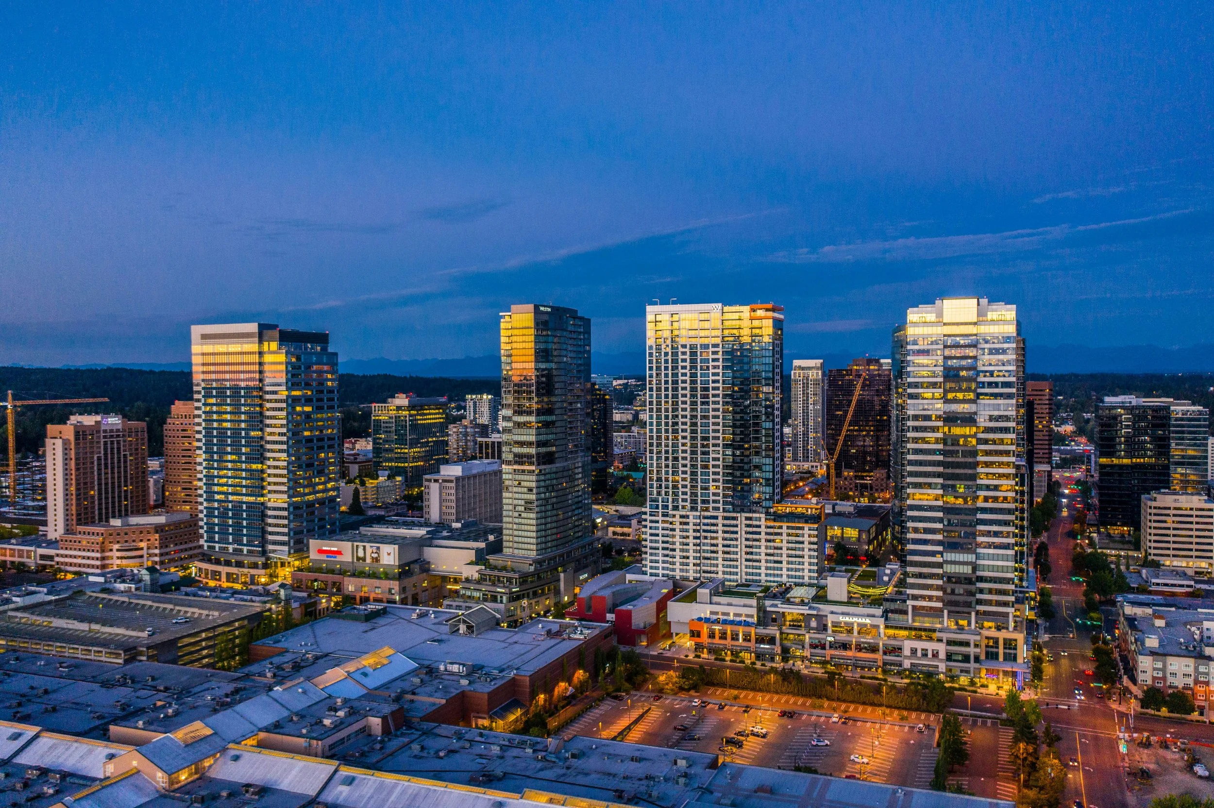 Downtown Bellevue skyline featuring luxury high-rise condominiums, waterfront access, and views of Lake Washington and Cascade Mountains