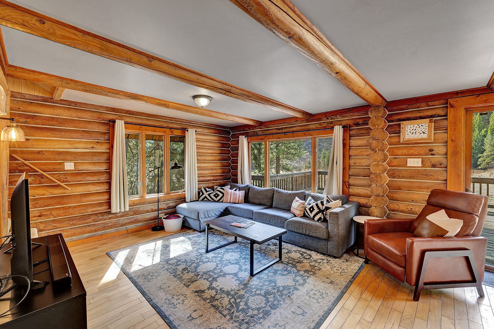 Interior living room of Pine Vista at 17336 Chumstick Hwy Leavenworth WA log cabin with vaulted ceilings skylights hardwood floors and handcrafted log wall construction
