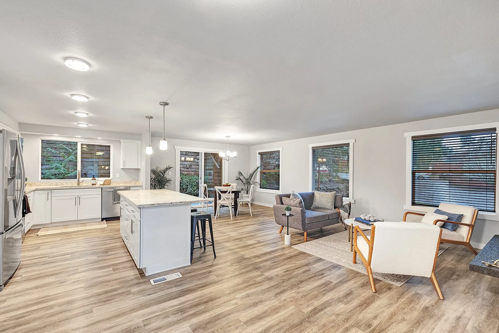 Bright open layout living space in updated Kenmore rambler connecting living room dining area and kitchen with abundant natural light