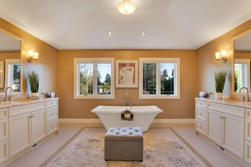 Spa-like primary bathroom with soaking tub, dual vanities, and luxury finishes in Clyde Hill home