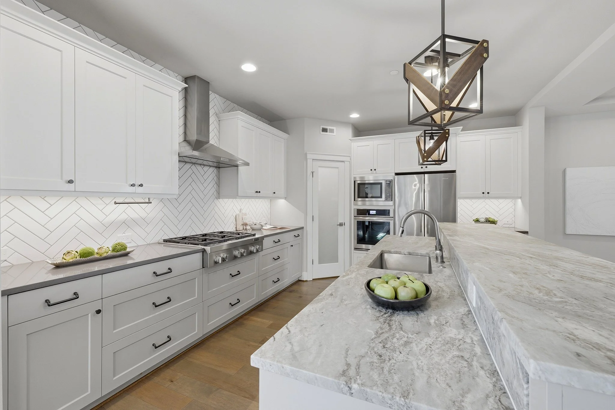 Kitchen with premium stainless appliances and herringbone tile backsplash, Redmond luxury home
