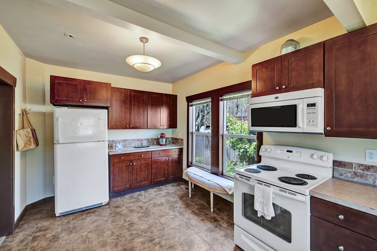 Updated kitchen with cherry cabinets, granite countertops, double-pane windows, and beam ceilings in Downtown Issaquah home