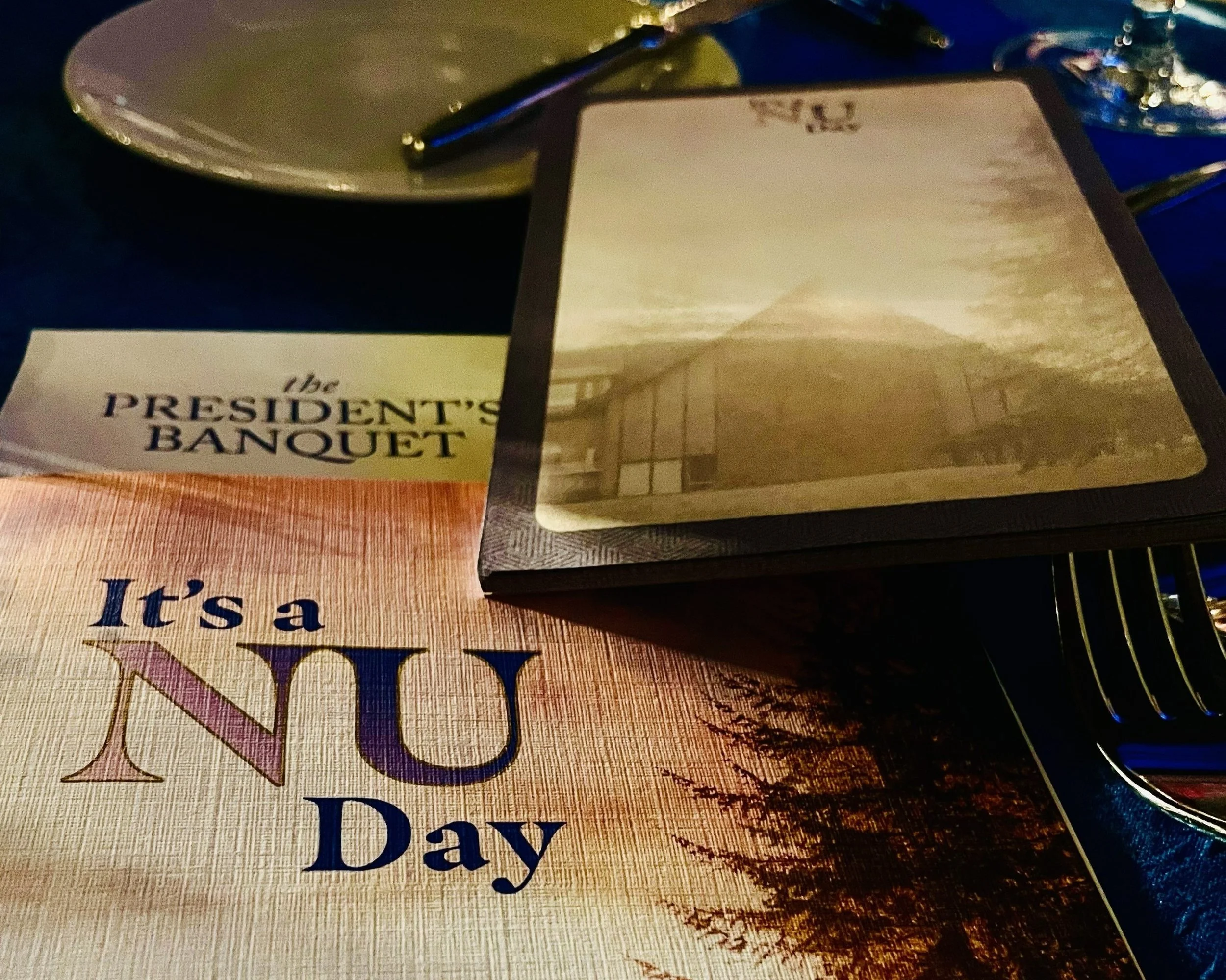 Northwest University Presidents Banquet table setting featuring the It's a NU Day program, 2025