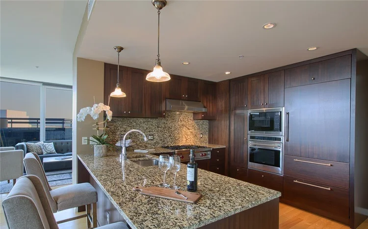 Gourmet kitchen with granite countertops and stainless steel appliances in a Bellevue Towers condo