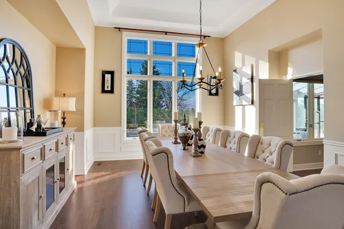 Elegant formal dining room with arched windows and designer lighting in Mediterranean Clyde Hill estate