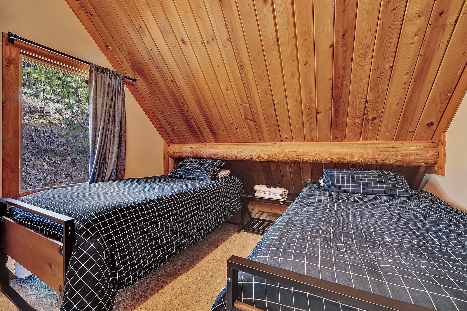 Separate twin bedroom with two twin beds at Pine Vista Leavenworth WA log cabin accommodating full 6-guest licensed capacity under Chelan County STR permit 000365